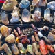 Overhead view of a wide assortment of natural rough crystals and gemstones in various colours and formations laid out on a flat surface, representing the range of stock evaluated in bulk wholesale crystal orders