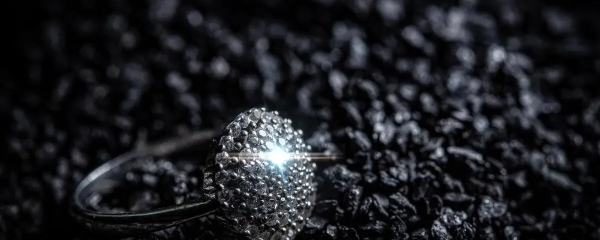 Meteorite ring resting on dark rocky material, showing metallic texture