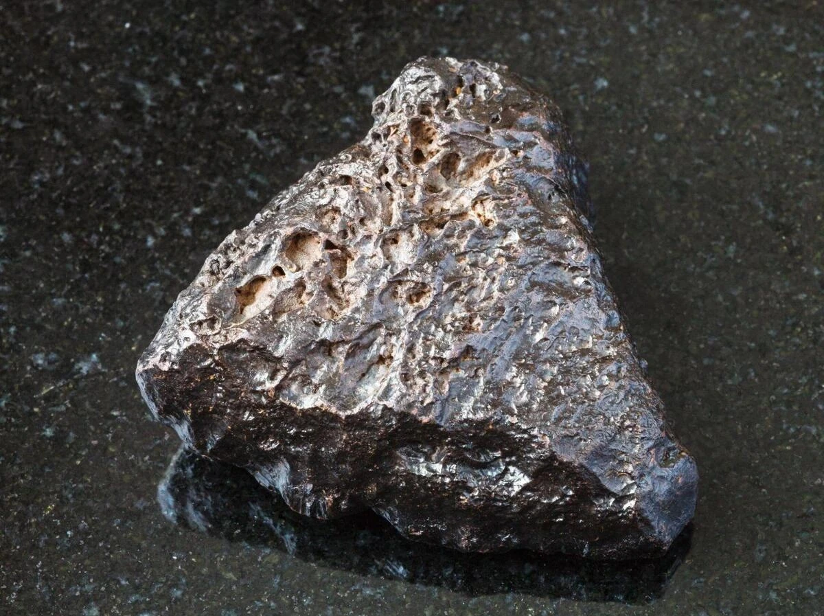Gibeon Meteorite Surface Patterns and Composition Close-up of a Gibeon meteorite highlighting its textured metallic surface before polishing and etching reveal its unique patterns.