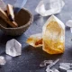 Citrine and clear quartz points arranged with palo santo sticks on dark slate